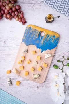 Composition cutting board with an abstract pattern, cheese, honey grapes, orc Stock Photos