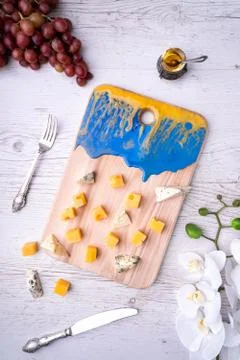 Composition cutting board with an abstract pattern, cheese, honey grapes, orc Fotos Stock