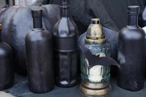 Composition of dark pumpkins, bottles, bats and a lantern for Halloween. Stock Photos