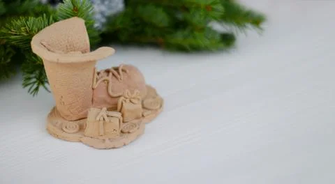 Composition with a decorative boot and New Year's gifts made of clay. Wooden  Stock Photos
