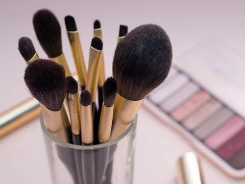Composition with decorative makeup products golden brushes and colorful eye s Stock Photos