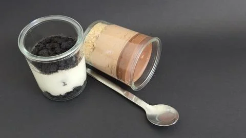 Composition of dessert jars and an angled spoon Stock Photos