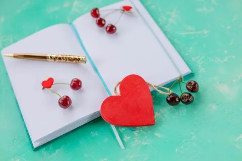 Composition with diary and sweet cherries and pen, open white paper note book Stock Photos