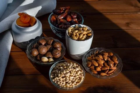 Composition of different delicious nuts and dried fruit under natural sunligh Stock Photos