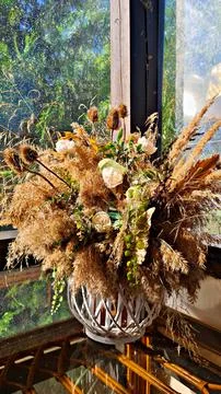 Composition of different dried flowers in vase is installed on veranda by t.. Stock Photos
