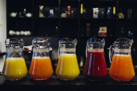 Composition of different fruit juices in pitchers Stock Photos