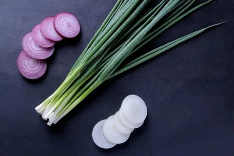 A composition from different kinds of onions on a dark blue background. top v Stock Photos