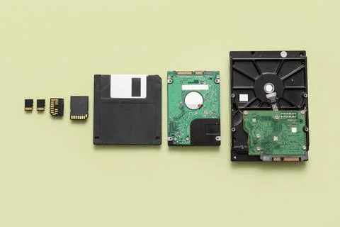Composition with different memory storage devices on green background Stock Photos