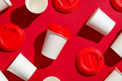 Composition with different paper cups and lids on red background, closeup Stock Photos