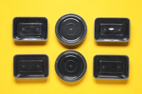 Composition with different plastic containers for food on yellow background Stock Photos