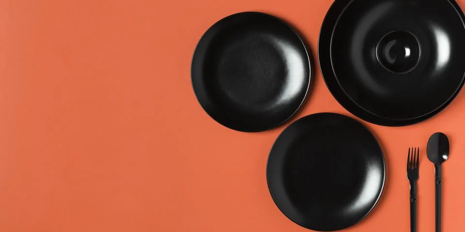 Composition of different sized plates on orange background with copy space Stock Photos