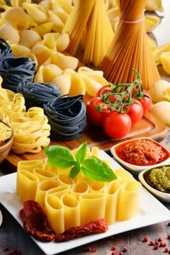 Composition with different sorts of pasta on kitchen table. Stock Photos