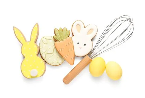 Composition with different tasty Easter cookies, eggs and whisk isolated on w Stock Photos