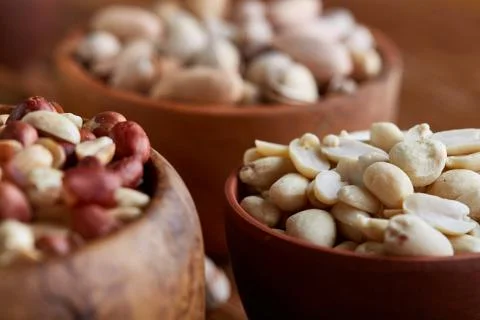 A composition from different varieties of nuts in a wooden bowls on rustic Stock Photos