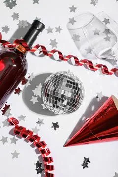 Composition with disco ball, bottle of wine and confetti on white background Stock Photos
