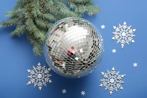 Composition with disco ball, Christmas decor and fir tree branch on blue back Stock Photos
