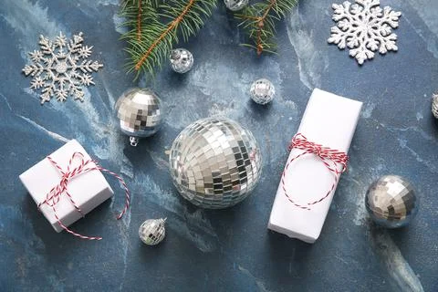 Composition with disco balls, fir tree branch and Christmas gift boxes on blu Stock Photos
