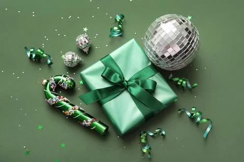 Composition with disco balls, gift box and Christmas decor on green backgroun Stock Photos