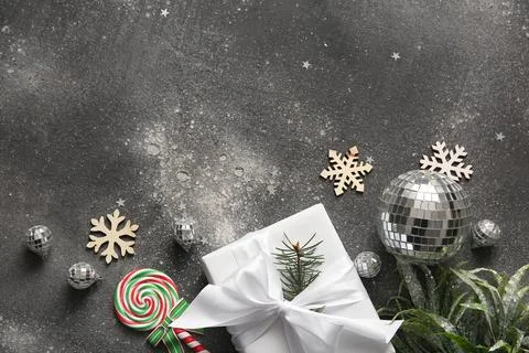 Composition with disco balls, gift box and Christmas decor on black grunge ba Stock Photos