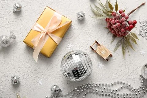 Composition with disco balls, gift box and Christmas decor on white grunge ba Stock Photos