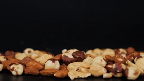 Composition with dried assorted nuts. Delicacies. Various nuts on stone table Stock Footage 98721134