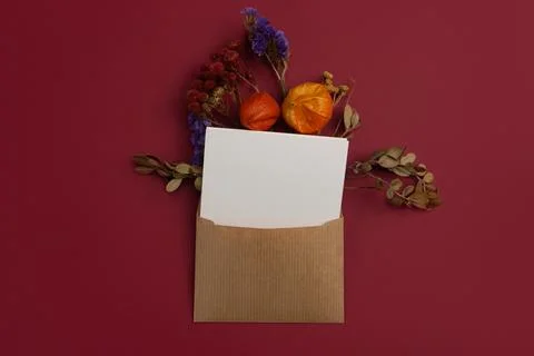 Composition of Dried Flowers on Craft Envelope Letter Mockup with Blank White Foto stock