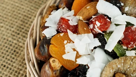Composition of dried fruits and nuts in small wicker bowl Video stock 103986418