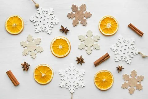 Composition with dry oranges, cinnamon sticks, anise stars and wooden snowfla Stock Photos