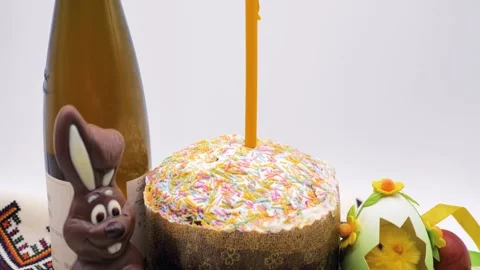 Composition of Easter cake with burning candle, chocolate rabbit and eggs Stock Footage 276312943