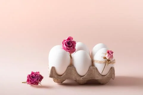 Composition with Easter eggs and eco-decor of dried roses on a beige background. Photos