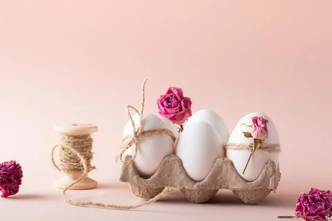 Composition with Easter eggs and eco-decor of dried roses on a beige background Stock Photos