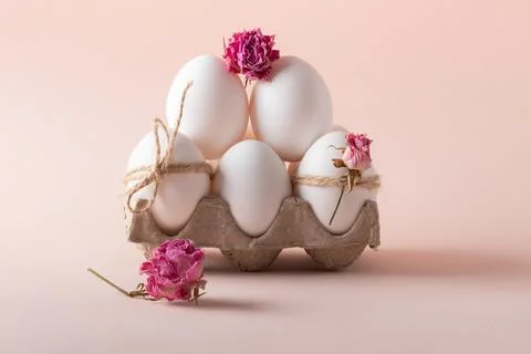 Composition with Easter eggs and eco-decor of dried roses on a beige background Stock Photos