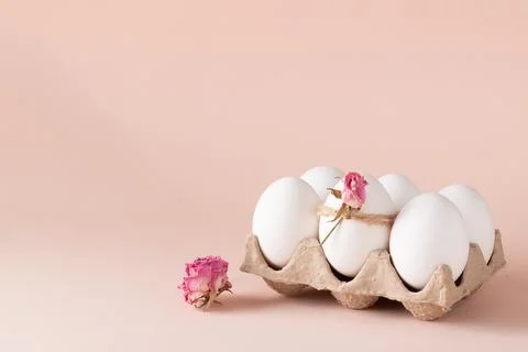 Composition with Easter eggs and eco-decor of dried roses on a beige background Stock Photos