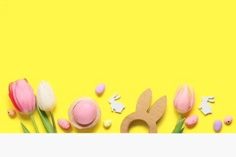 Composition with Easter eggs and tulip flowers on yellow background Stock Photos