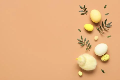 Composition with Easter eggs, baby chicken and green leaves on brown backgrou Stock Photos