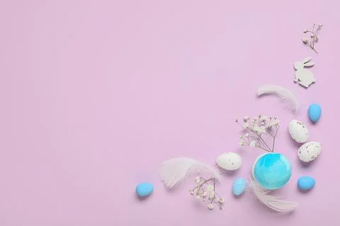 Composition with Easter eggs, feathers and gypsophila flowers on lilac backgr Stock Photos