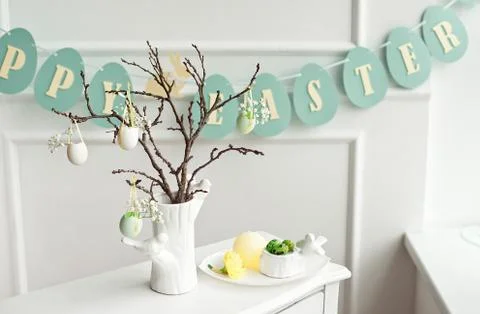 Composition with Easter eggs in glass jar and wicker basket, and blooming Stock-Fotos