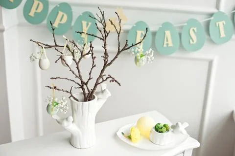 Composition with Easter eggs in glass jar and wicker basket, and blooming Stock Photos