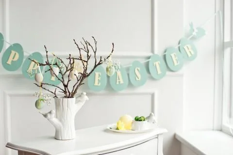 Composition with Easter eggs in glass jar and wicker basket, and blooming Stock Photos