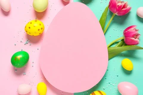 Composition with egg-shaped blank card, sprinkles, flowers and Easter eggs on Stock Photos