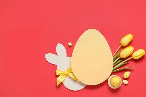 Composition with egg-shaped blank card, Easter eggs and tulip flowers on red  Stock Photos