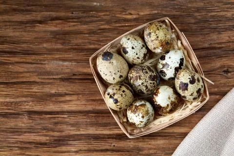 Composition of eggs quail box, eggs on a homespun napkin, boxwood on wooden Stock Photos