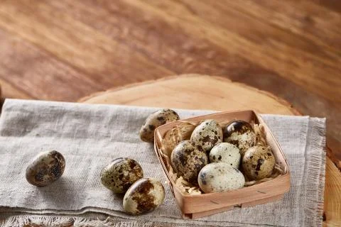 Composition of eggs quail box, eggs on a homespun napkin on a log over wooden Stock Photos