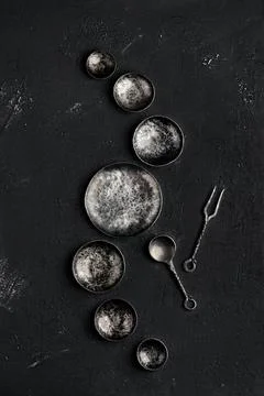 Composition with empty forged bowls of different size on black background Stock Photos
