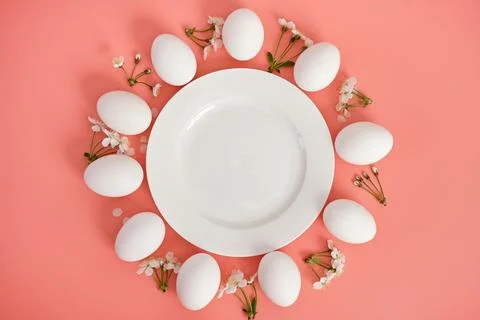 Composition with an empty plate, Easter eggs and beautiful flowers on a pink Stock Photos