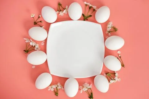 Composition with an empty plate, Easter eggs and beautiful flowers on a pink Stock Photos
