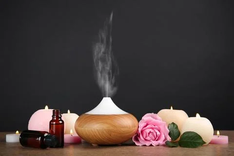 Composition with essential oils diffuser on table against black background. S Stock Photos