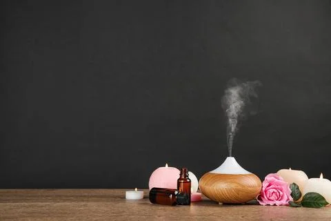 Composition with essential oils diffuser on table against black background. S Stock Photos