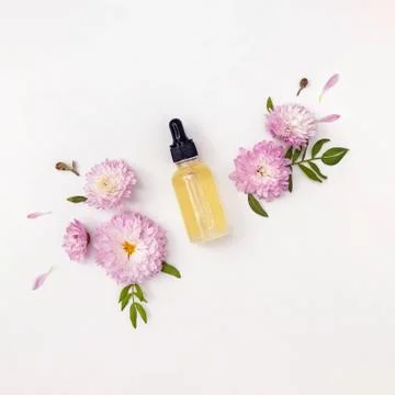 Composition with face serum or essential oil and flowers Foto stock