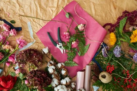Composition flat-lay of flowers and florists instruments on parchment paper Stock Photos